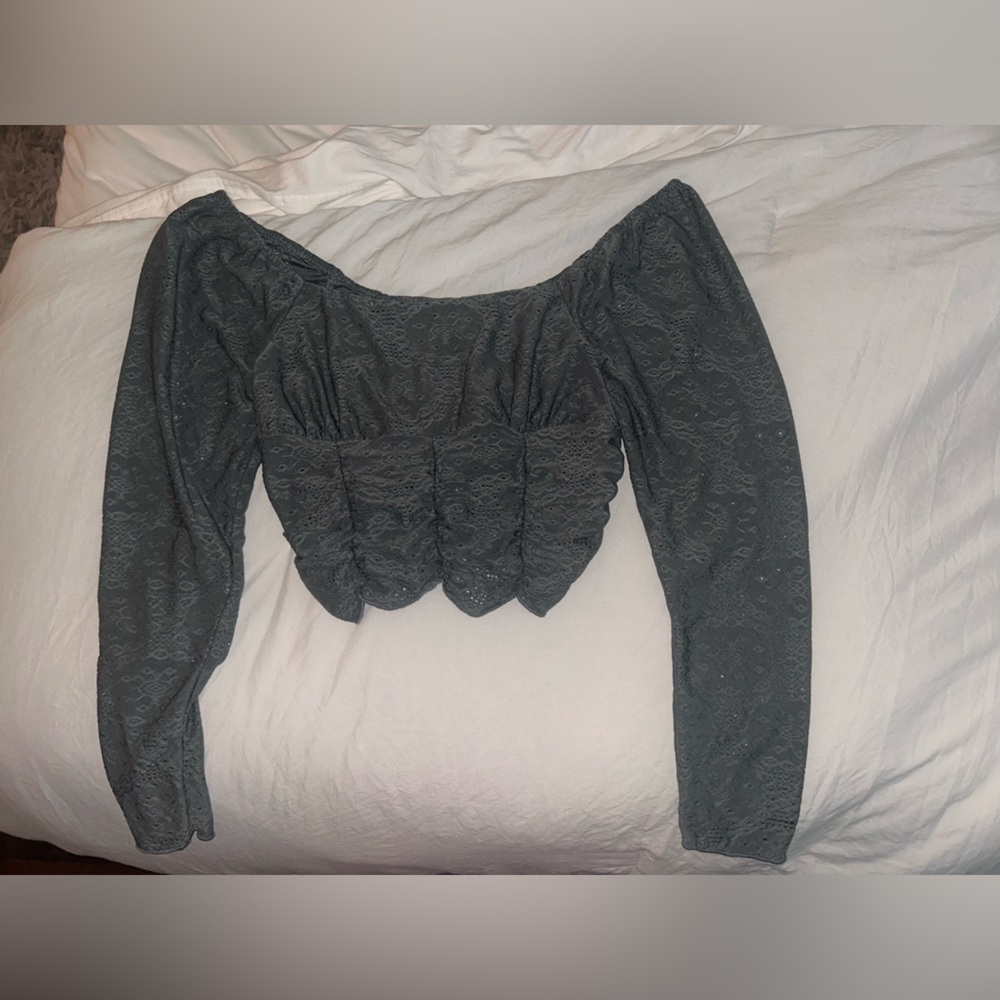 Cropped long sleeve. Material looks like lace but isn’t.